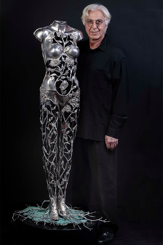 Artist Michael Galmer standing with his sculpture 'Chrysanthemum Woman'.